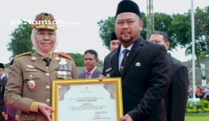 PROFIL: Gubernur Jatim Khofifah Indar Parawansa menyerahkan penghargaan kepada Bupati Gersik Gus Yani (dok: istimewa/Redaksi Rekam Satu)