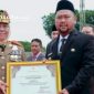 PROFIL: Gubernur Jatim Khofifah Indar Parawansa menyerahkan penghargaan kepada Bupati Gersik Gus Yani (dok: istimewa/Redaksi Rekam Satu)