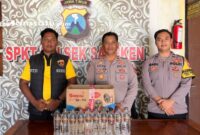 PROFIL : Petugas kepolisian menunjukkan BB minuman keras yang berhasil diamankan (dok: istimewa/Redaksi Rekam Satu)