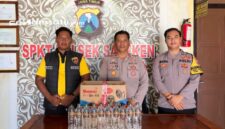 PROFIL : Petugas kepolisian menunjukkan BB minuman keras yang berhasil diamankan (dok: istimewa/Redaksi Rekam Satu)