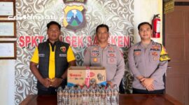 PROFIL : Petugas kepolisian menunjukkan BB minuman keras yang berhasil diamankan (dok: istimewa/Redaksi Rekam Satu)