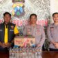 PROFIL : Petugas kepolisian menunjukkan BB minuman keras yang berhasil diamankan (dok: istimewa/Redaksi Rekam Satu)
